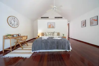 a bedroom with a bed and a clock on the wall at \u5c71\u6d77\u306e\u5922 1600\u5e73\u8c6a\u534e\u79c1\u4eba\u6cf3\u6c60\u522b\u5885 15m\u8d85\u5927\u6cf3\u6c60 \u6b65\u884c\u6d77\u8fb9 \u514d\u8d39\u65e9\u9910 \u4f63\u4eba in Phuket Town