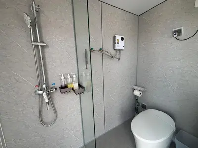 a bathroom with a shower with a toilet and a glass shower door at Space House Hotel Phuket in Rawai Beach