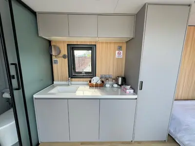 a small kitchen with white cabinets and a sink at Space House Hotel Phuket in Rawai Beach