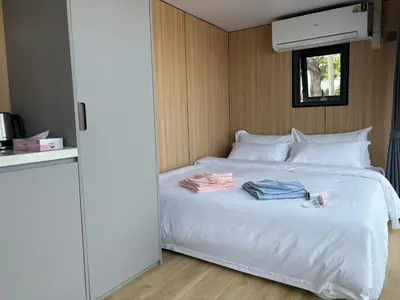 a bedroom with a white bed with clothes on it at Space House Hotel Phuket in Rawai Beach