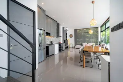 a kitchen with a table and a dining room at \u6668\u6d77\u306e\u5922\u4e09\u5367\u79c1\u4eba\u82b1\u56ed\u6cf3\u6c60\u522b\u5885 in Ban Pak Lak