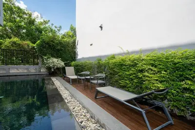 a pool with tables and chairs next to a building at \u6668\u6d77\u306e\u5922\u4e09\u5367\u79c1\u4eba\u82b1\u56ed\u6cf3\u6c60\u522b\u5885 in Ban Pak Lak