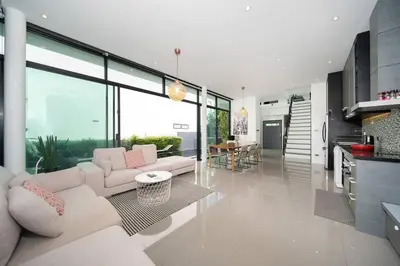 a living room with white furniture and large windows at \u6668\u6d77\u306e\u5922\u4e09\u5367\u79c1\u4eba\u82b1\u56ed\u6cf3\u6c60\u522b\u5885 in Ban Pak Lak