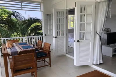 a room with a table and chairs and a balcony at Ocean breeze studio 1 bed in Ban Pak Lak