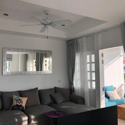 a living room with a couch and a ceiling fan at Ocean breeze studio 1 bed in Ban Pak Lak