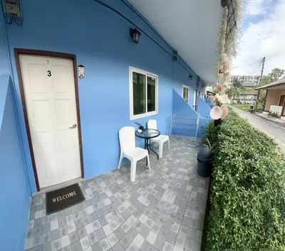 a blue building with a door and a table and chairs at Yada House s&h in Nai Yang Beach