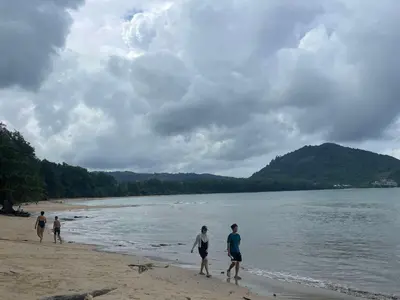 a group of people walking on the beach at Yada House s&h in Nai Yang Beach