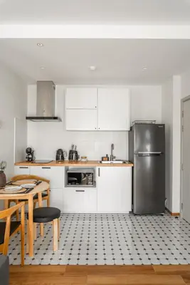 a kitchen with white cabinets and a stainless steel refrigerator at Title Halo Memories Naiyang Pool Gym Sauna in Nai Yang Beach