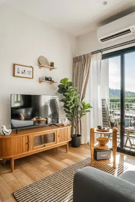 a living room with a tv and a couch at Title Halo Memories Naiyang Pool Gym Sauna in Nai Yang Beach