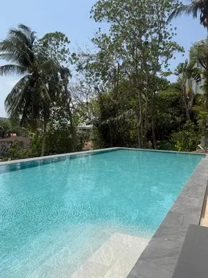 a large blue swimming pool with trees in the background at Apartment Karon SeaView 72 sq in Karon Beach
