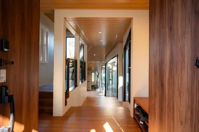 a hallway of a house with wooden floors and windows at Sinae Residence in Ban Lo Ti Pa (1)