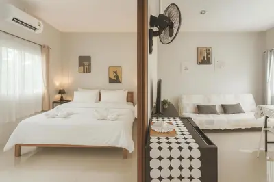 a bedroom with two beds and a clock on the wall at Yada House s&s in Nai Yang Beach