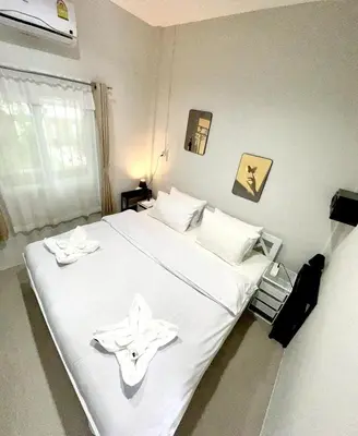 a bedroom with a white bed with white towels on it at Yada House s&s in Nai Yang Beach