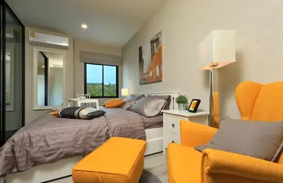 a bedroom with a bed and two orange chairs at 300 m to Naiyang Beach by Capital Pro in Nai Yang Beach