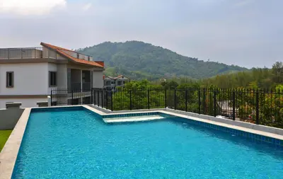 a swimming pool in front of a house at 300 m to Naiyang Beach by Capital Pro in Nai Yang Beach