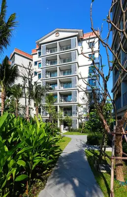 a tall white building with a pathway in front of it at 300 m to Naiyang Beach by Capital Pro in Nai Yang Beach