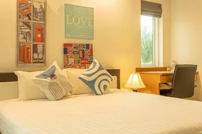 a bedroom with a bed with pillows and a desk at 15 Minuets Walk 2 BangTao Beach Fully Loaded v134 in Bang Tao Beach
