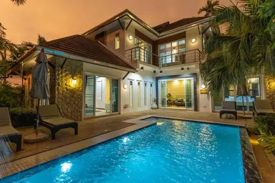 a house with a swimming pool in front of a house at 15 Minuets Walk 2 BangTao Beach Fully Loaded v134 in Bang Tao Beach