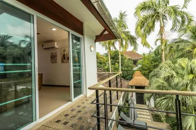 a balcony of a house with palm trees at 15 Minuets Walk 2 BangTao Beach Fully Loaded v134 in Bang Tao Beach