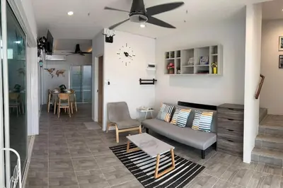a living room with a couch and a clock on the wall at Bang Tao Town House 1km Surin Beach V135 in Thalang