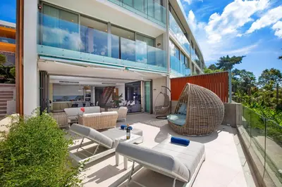 a patio of a building with chairs and a table at Sea View 3BR Duplex in The Sapphire Bay 88 Residence near Patong and Paradise Beach in Patong Beach