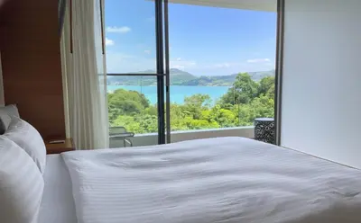 a bedroom with a large bed and a large window at Sea View 3BR Duplex in The Sapphire Bay 88 Residence near Patong and Paradise Beach in Patong Beach