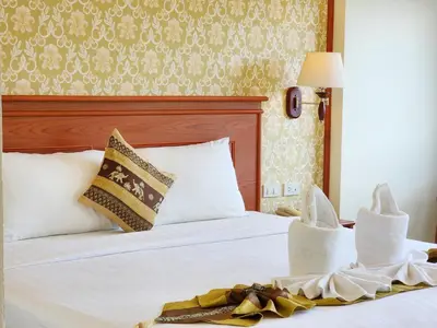 a hotel room with a white bed with a headboard at Phaithong Sotel Resort in Chalong