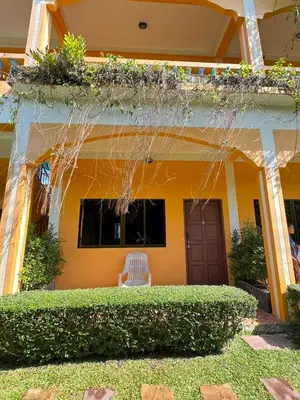a yellow house with a bench in front of it at Mood Resotel Kamala in Kamala Beach