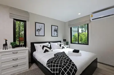 a bedroom with a bed and two windows at Apart Pool Access Naiyang Beach in Nai Yang Beach