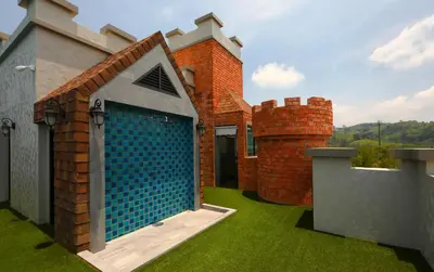 a brick building with a blue door in the yard at Apart Pool Access Naiyang Beach in Nai Yang Beach