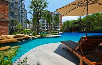 a chair and an umbrella next to a swimming pool at Apart Pool Access Naiyang Beach in Nai Yang Beach