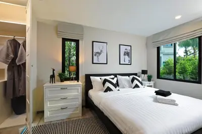 a bedroom with a large white bed and windows at Apart Pool Access Naiyang Beach in Nai Yang Beach
