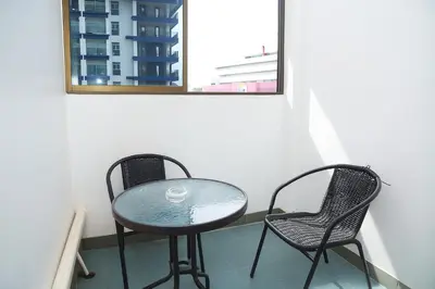 a glass table and two chairs on a balcony at Burning Flame Patong in Patong Beach