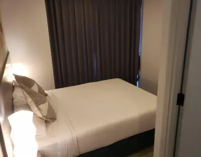 a bedroom with a white bed with a pillow at Chalong Pier apartement in Phuket Town