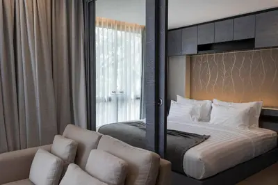 a bedroom with a bed with a mirror and a couch at Fully Loaded Resort everything You Need #C142 in Kamala Beach