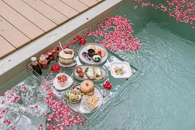 a table with plates of food on top of water at Timber Society Boutique Hideaway in Phuket Town