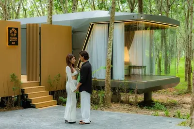 a bride and groom standing in front of a house at Timber Society Boutique Hideaway in Phuket Town