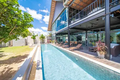 an outdoor swimming pool in front of a building at BangTao 6-bedroom villa 18 meters, competition-grade swimming pool, industrial style design aesthetic, gaming and entertainment floor, suitable for family vacations and group gatherings in Bang Tao Beach