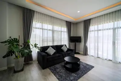 a living room with a couch and a large window at Pool Villa Alawan Krabi Klong Muang R2 in Klong Muang Beach