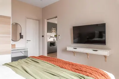 a bedroom with a flat screen tv on a wall at Title Halo Orange Sunset 46m2 Naiyang Pool&Gym in Nai Yang Beach