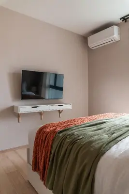 a bedroom with a flat screen tv on a wall at Title Halo Orange Sunset 46m2 Naiyang Pool&Gym in Nai Yang Beach