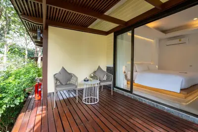 a bedroom with a bed on a wooden deck at Anona Sunset Boutique in Karon Beach