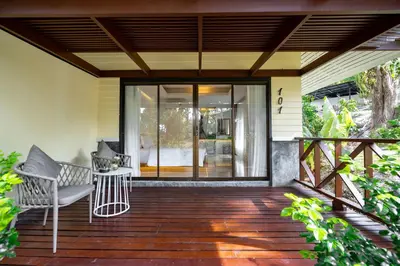a wooden deck with a chair on a house at Anona Sunset Boutique in Karon Beach
