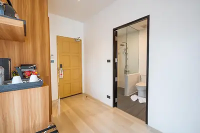 a bathroom with a toilet and a glass door at Anona Sunset Boutique in Karon Beach