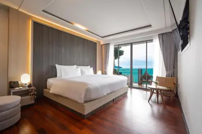 a bedroom with a bed and a view of the ocean at Anona Sunset Boutique in Karon Beach