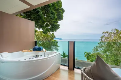 a bath tub in a room with a view of the ocean at Anona Sunset Boutique in Karon Beach