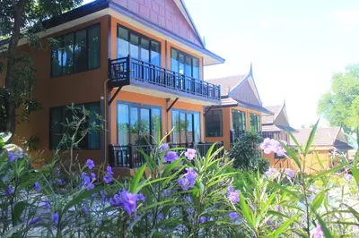 a house with purple flowers in front of it at Phi Phi Long Beach Resort & Villa in Phi Phi Don