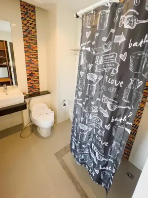 a bathroom with a toilet and a shower curtain at Melissa Kata Beach Resort in Kata Beach