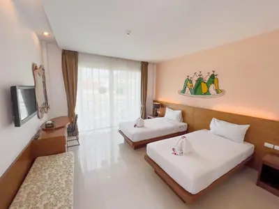 a hotel room with two beds and a tv at Melissa Kata Beach Resort in Kata Beach