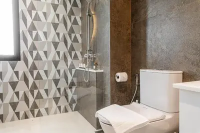 a bathroom with a shower and a white toilet at Title Halo Modern Line Pool View Gym Sauna in Nai Yang Beach